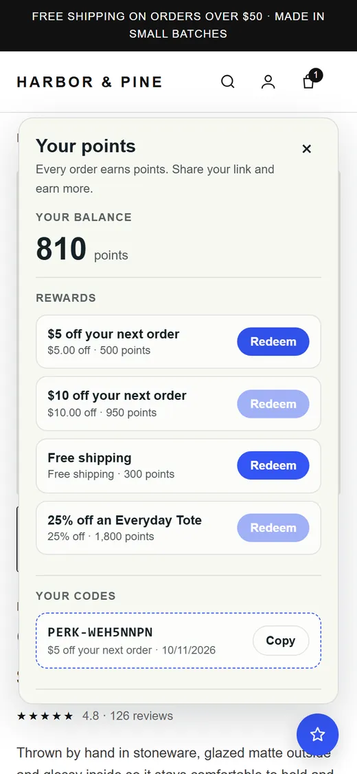 Phone screen after redeeming: the panel shows a single-use PERK code with a copy button.